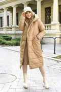 Woman wearing a long beige puffer coat in an urban setting